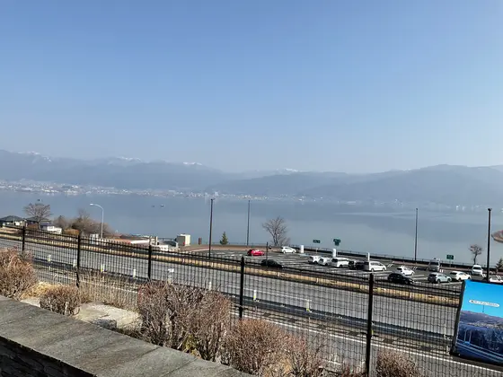 遠くに山並みが見えます。手前は諏訪湖。