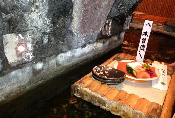 中央にデンと構える大きな岩山、その周囲を緩やかに流れる川、そして筏に乗った手打ち蕎麦！