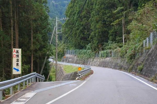 温泉はこの看板から坂の下に