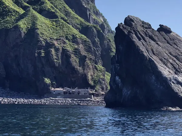 廃墟の番屋と屏風岩
