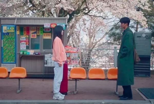 お別れの挨拶をする桜の下のバス停